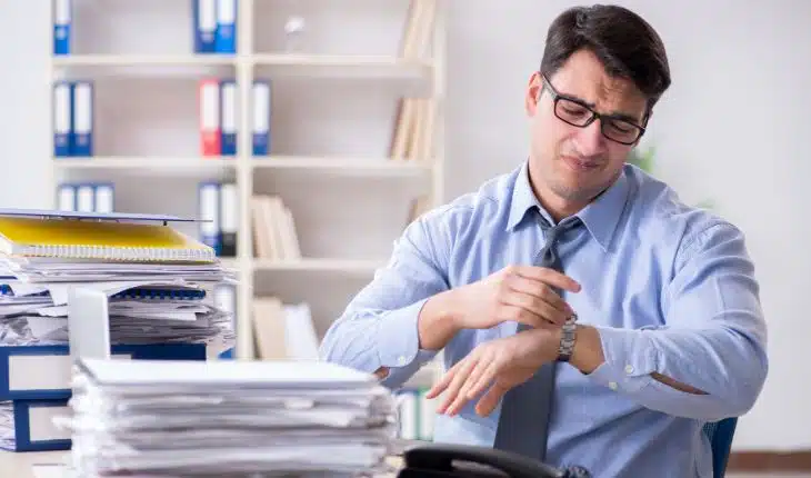 homem estressado atrás de uma mesa de escritório Doença arterial coronariana 